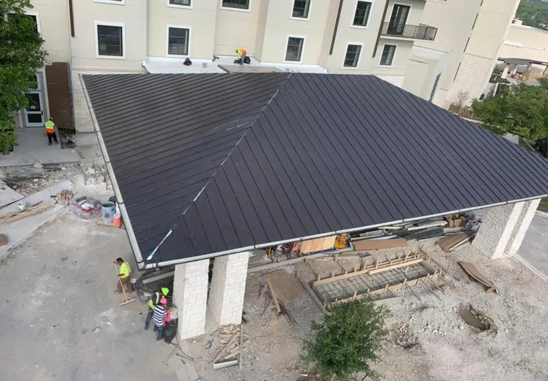 Metal roofing installation team working on a commercial building in Byron